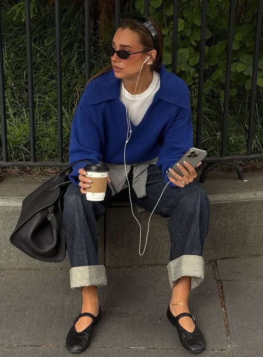 Danielle Bernstein wearing new fall blue sweater sitting on curb outside in NYC