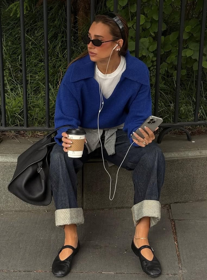 Danielle Bernstein wearing new fall blue sweater sitting on curb outside in NYC