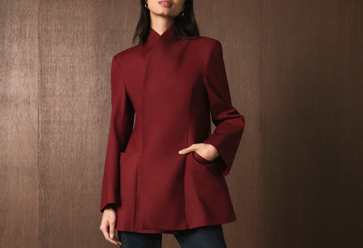 Model wearing burgundy WeWoreWhat hourglass blazer with a wooden background