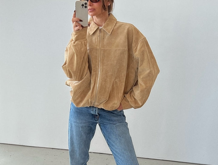 Danielle Bernstein taking a mirror selfie in the WeWoreWhat premium suede bomber jacket
